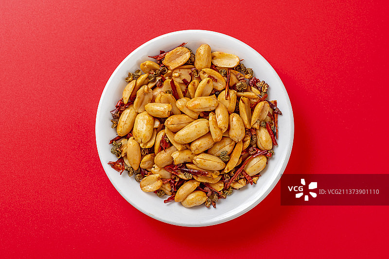 一盘麻辣花生特写红色背景图片素材