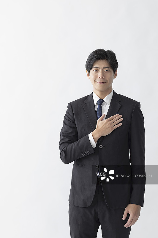 商业男性把手放在胸前微笑地作手势图片素材