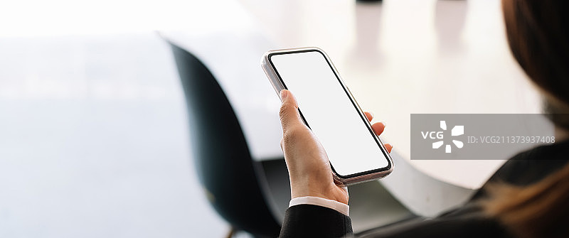 女人手持空白屏幕的手机特写图片素材