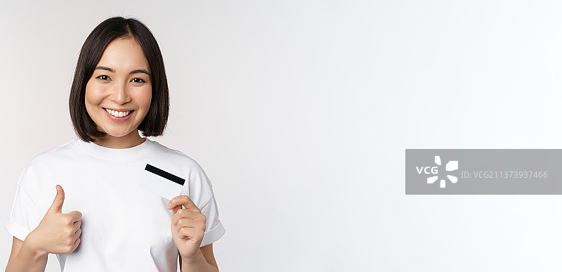 展示信用卡的年轻时尚亚洲女性肖像照图片素材