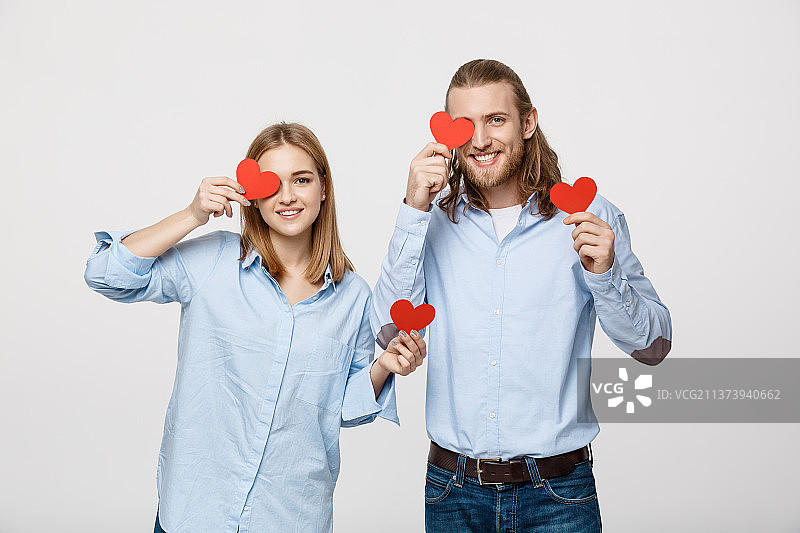 充满爱意的年轻情侣用红心遮住眼睛图片素材