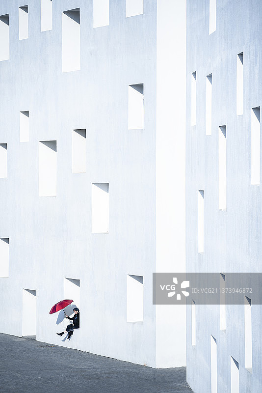 中国深圳大学充满设计感的教学楼里打伞的女子图片素材