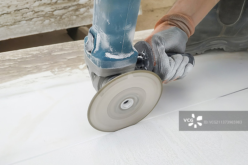 切割角磨机大理石板，在内坦亚以色列的地板上工作的人的低角度拍摄图片素材