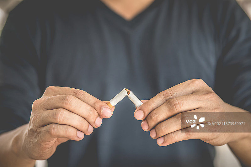 男人在家中折断香烟，戒烟概念图片素材