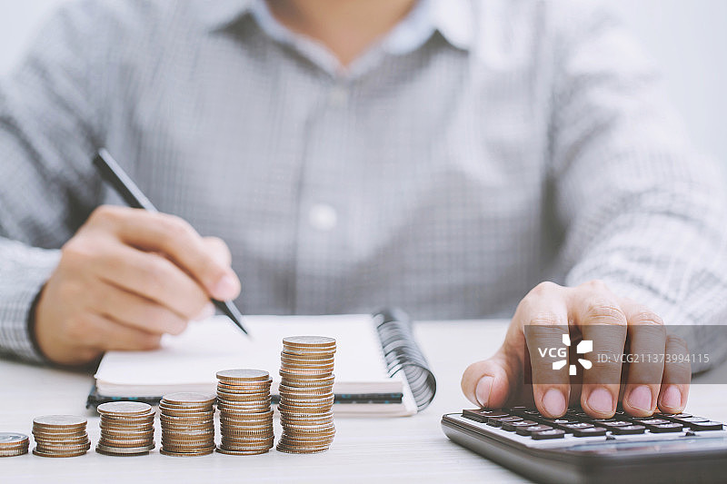 商人拿着硬币，计算桌子上的硬币图片素材