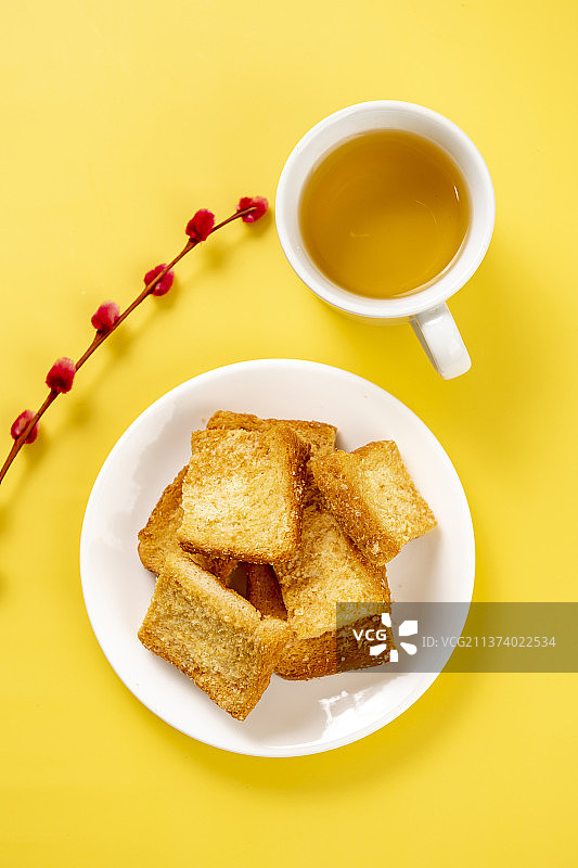 一盘面包干与茶水特写木桌面背景图片素材
