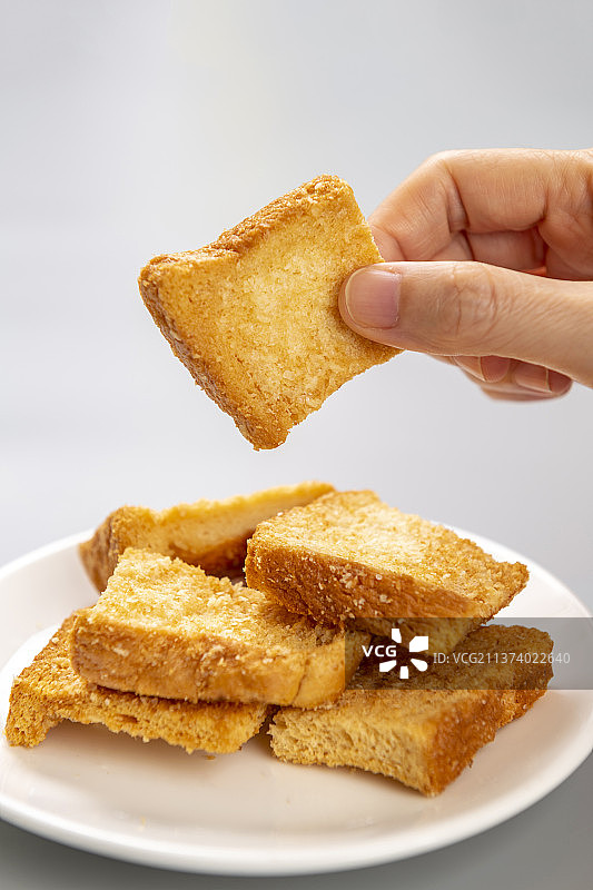 手拿面包干特写灰色图片素材