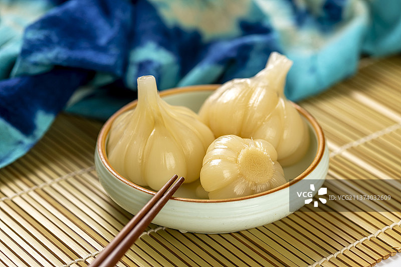 一盘糖蒜甜蒜摆放在竹席上特写图片素材