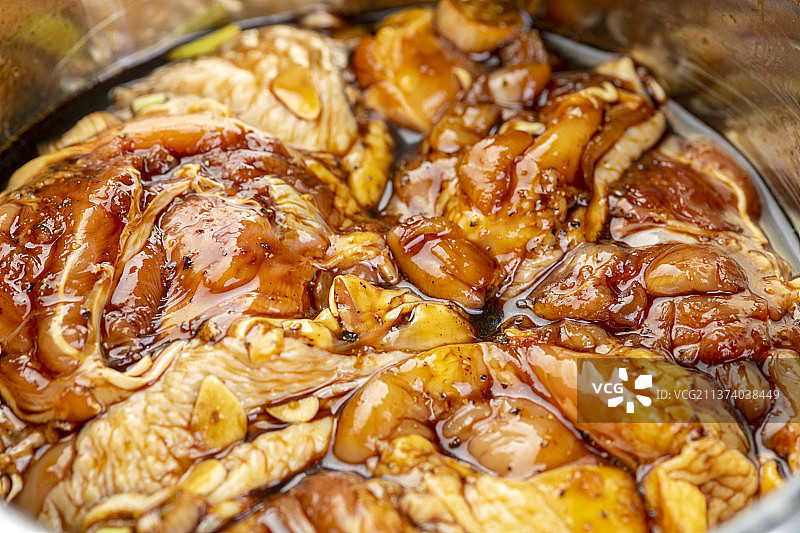 正在腌制的鸡腿特写绿色背景图片素材