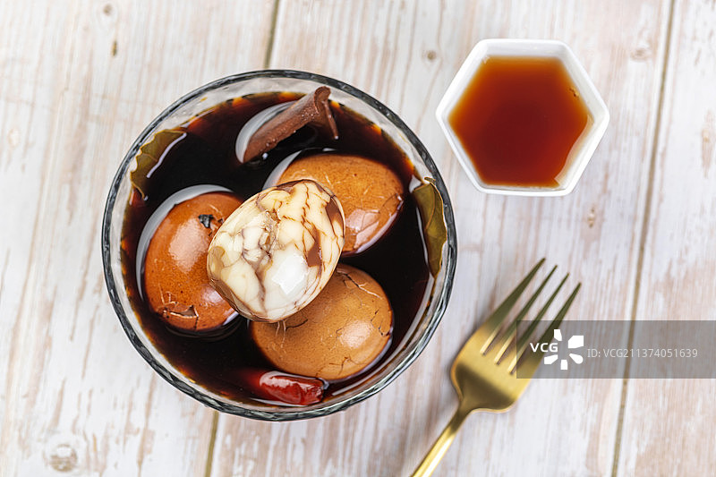 茶叶鸡蛋与茶水特写木桌面背景图片素材