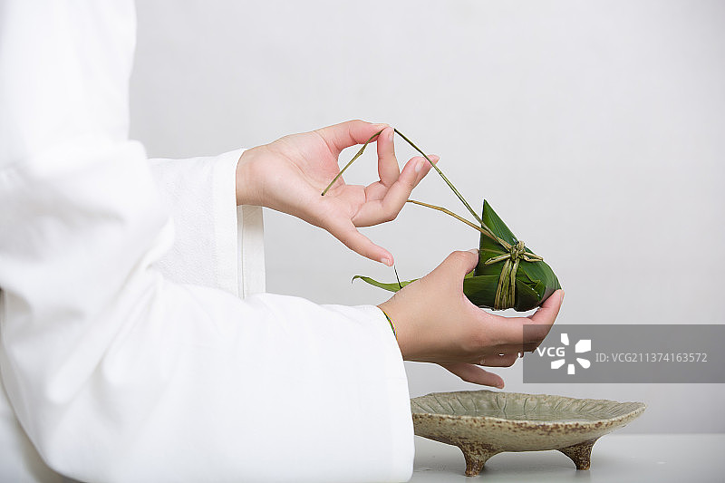端午节中国风禅意静物：穿汉服女子包粽子图片素材