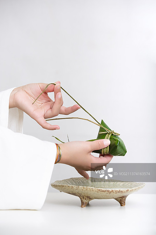 端午节中式国潮禅意静物：穿汉服女子包粽子图片素材