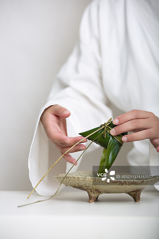 端午节中式国潮禅意静物：穿汉服女子包粽子图片素材
