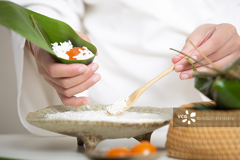 端午节中式国潮禅意静物：穿汉服女子包蛋黄粽子图片素材