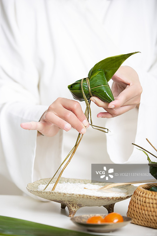 端午节中式国潮禅意静物：穿汉服女子包粽子图片素材