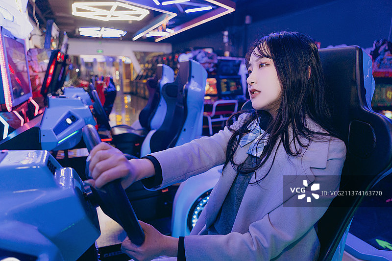 亚洲美女在电玩城玩赛车游戏图片素材