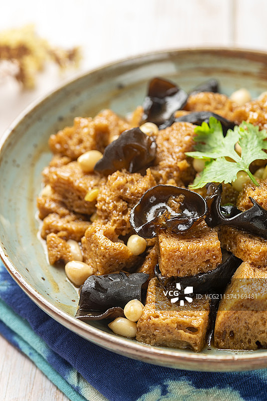 一盘烤麸摆放在木桌面上特写图片素材