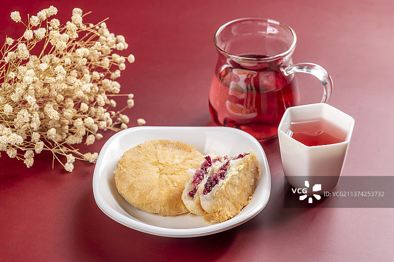 一盘鲜花饼与玫瑰茶花瓣特写红色莫兰迪色系背景图片素材