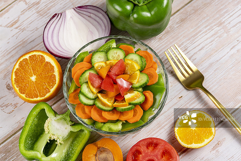 一碗蔬菜沙拉特写旁边放有各种果蔬木桌面背景图片素材