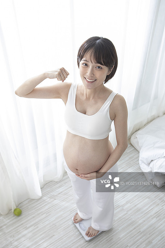 孕妇站在体重机上量体重图片素材