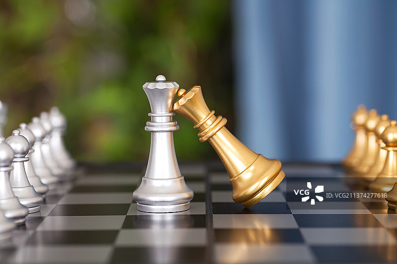 国际象棋双方对阵之时金色一方的王后棋子投降图片素材