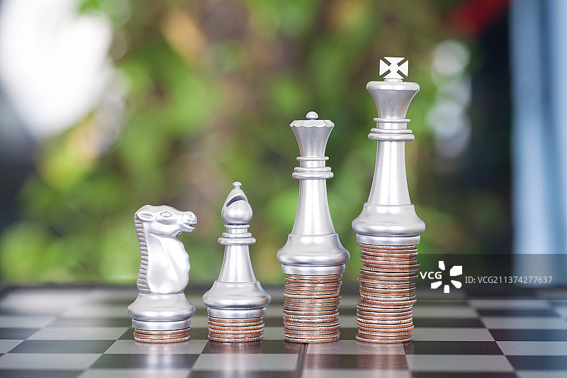 棋盘上一排美元硬币和各种各样的国际象棋棋子图片素材