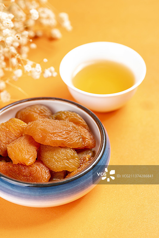 一盘果脯杏干茶水摆放在桌面上特写图片素材