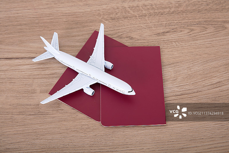 两本护照上一个小飞机模型图片素材
