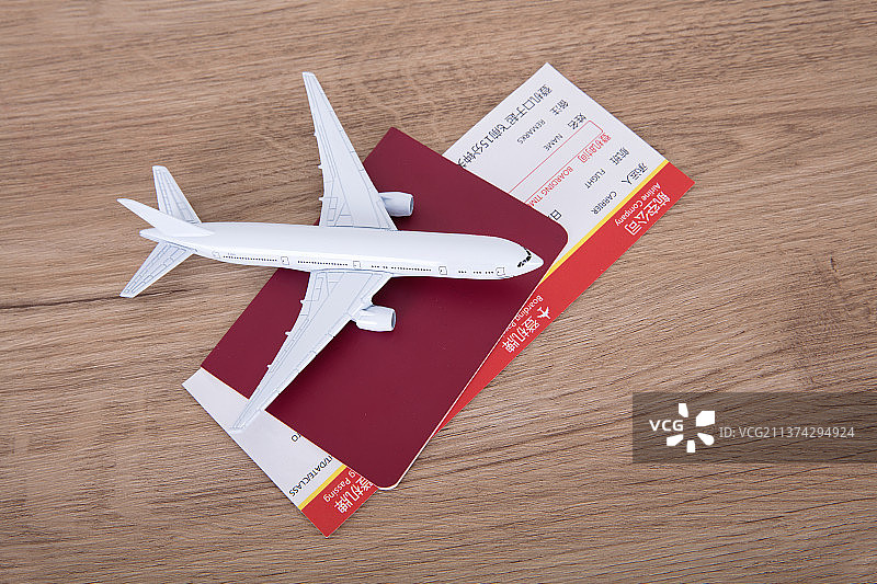 一个白色的小飞机模型在夹着飞机票的护照上图片素材