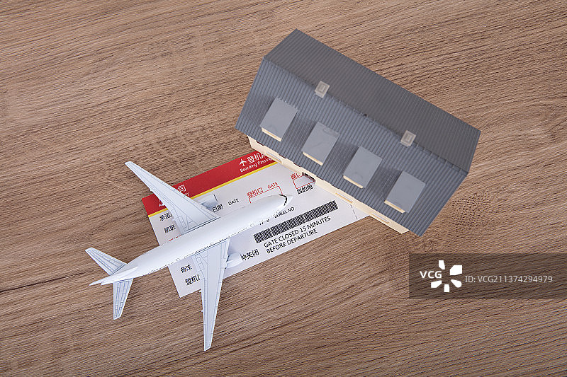 桌子上的飞机模型和机票及家的模型图片素材