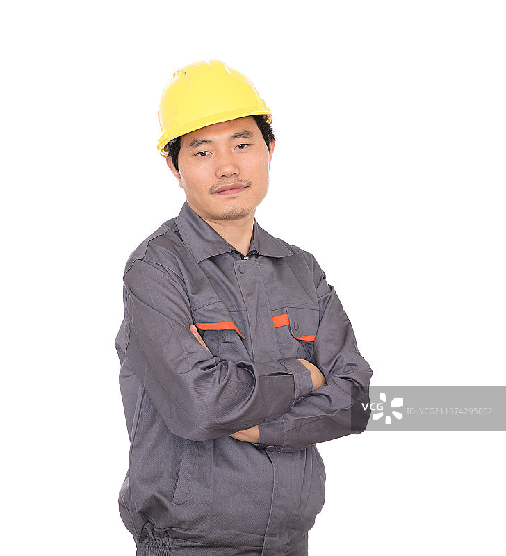 头戴黄色安全帽的农民工抱手站在白背景前图片素材