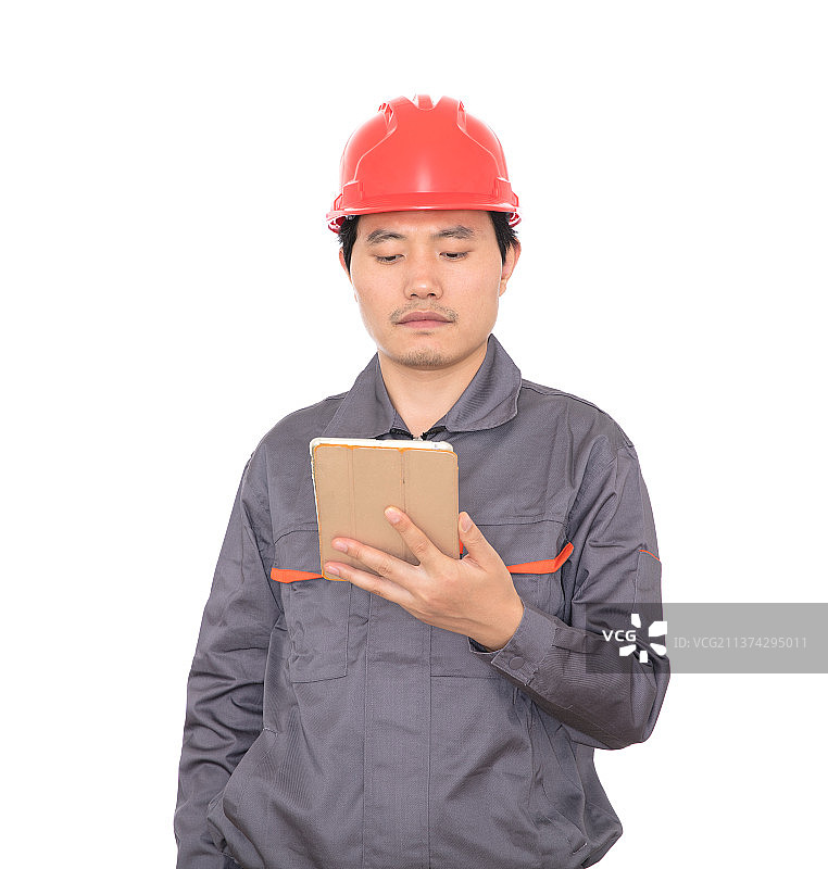 带着红色安全帽的建筑工人手拿ipad站在白背景前脸看镜头图片素材