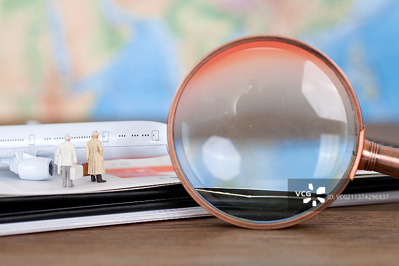 台历上登机的人群模型和一个放大镜图片素材