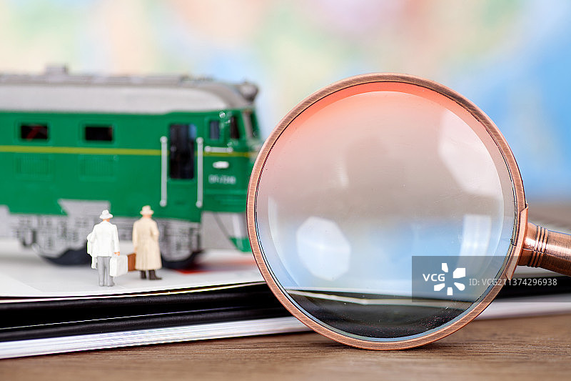 台历上乘火车的人群模型和一个放大镜图片素材