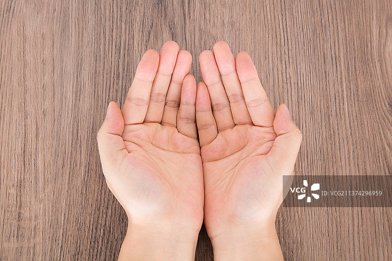 双手在桌子上并在一起做接东西的手势图片素材