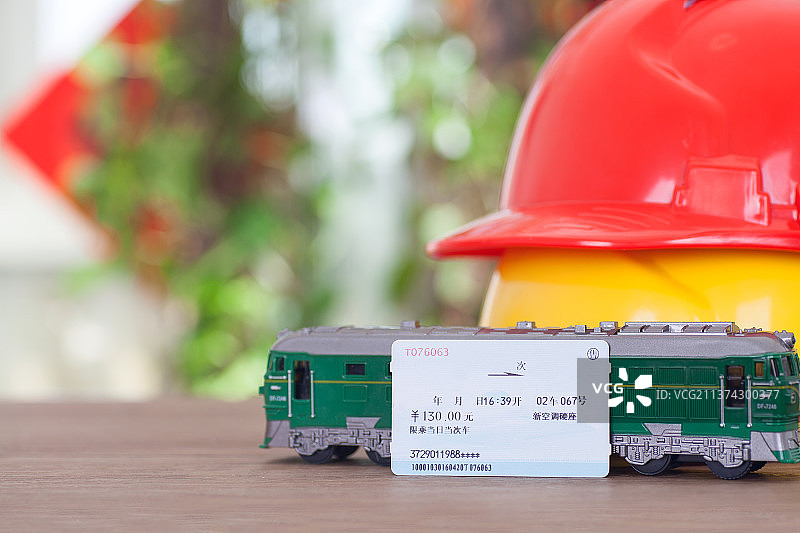 民工安全帽和火车模型及一张火车票图片素材
