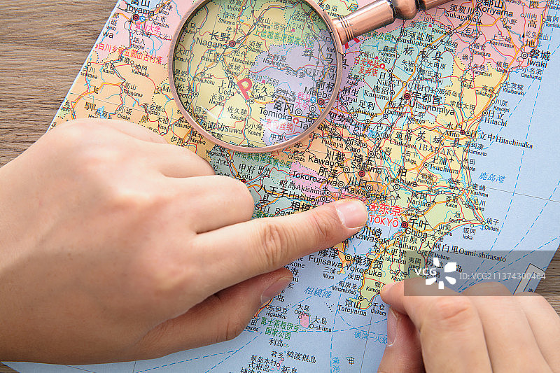 两只手指着地图上日本首都东京的位置图片素材
