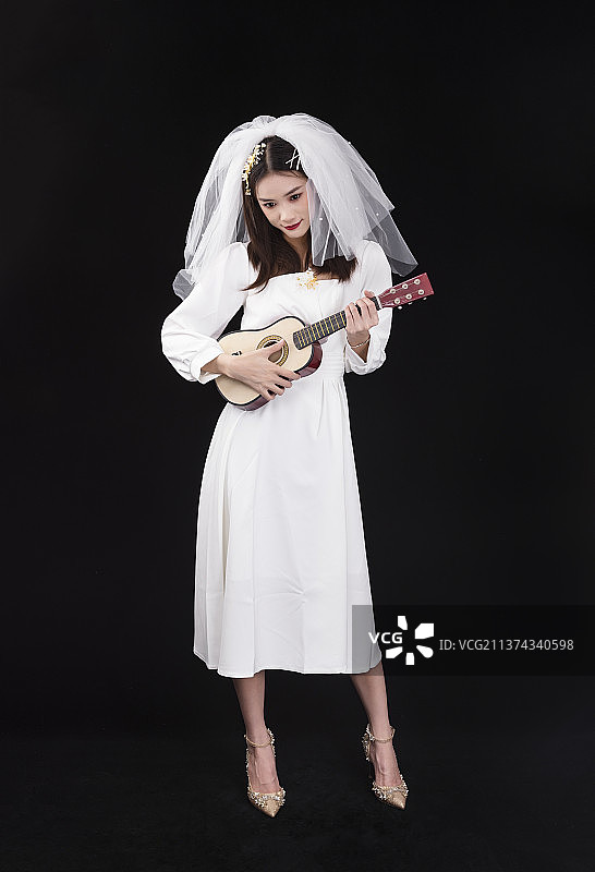 穿着白色连衣裙戴着头纱的年轻女性图片素材