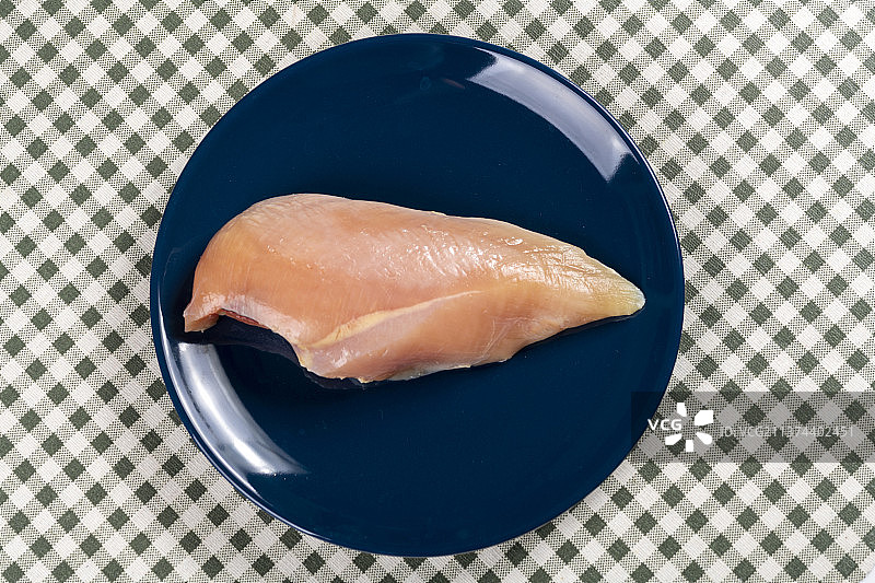 一块鸡胸肉摆放在桌面上特写图片素材
