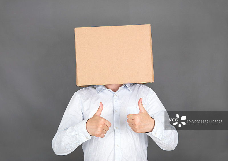 头戴纸箱的男士双手大拇指点赞图片素材