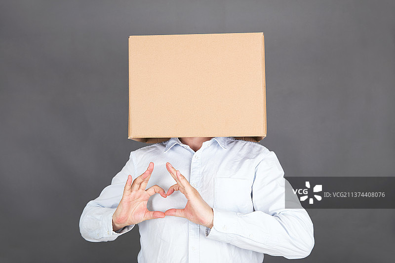 头戴纸箱的男士双手摆出心形图片素材