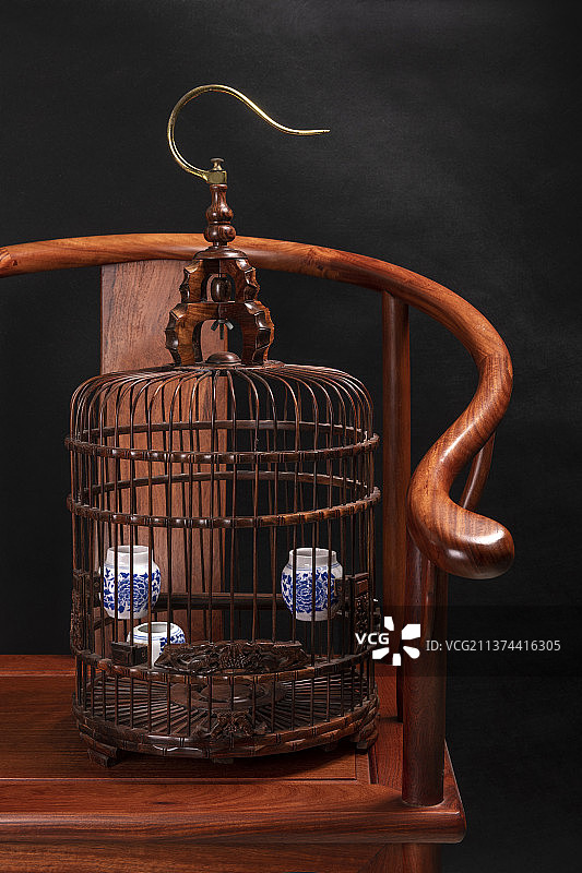 红木鸟笼放在圈椅上深色调图片素材