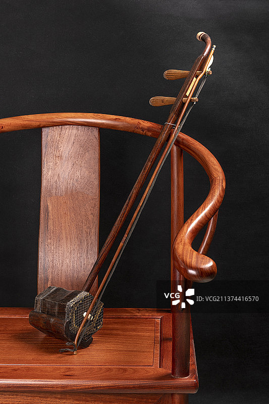 一把二胡放在圈椅上特写深色调图片素材