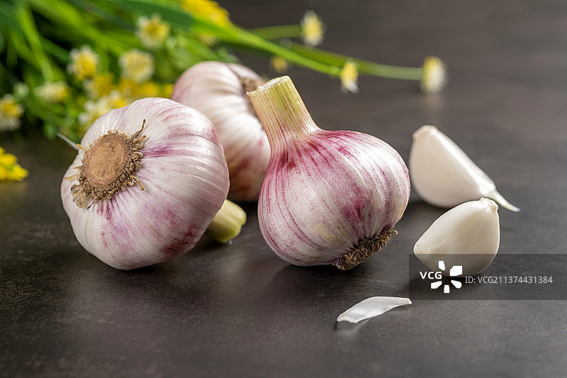 一簸箕新鲜大蒜摆放在桌面上图片素材