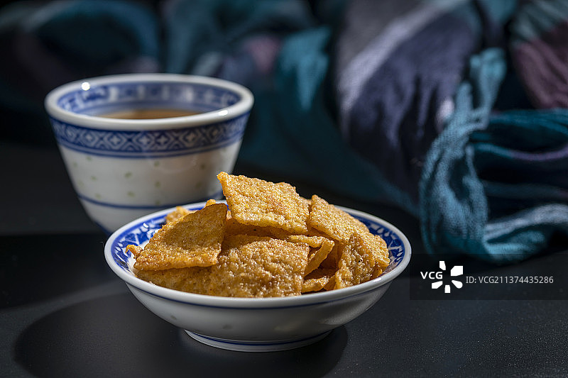 休闲零食小米锅巴与茶水摆放在桌面上特写图片素材