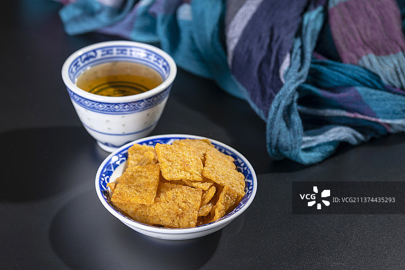 休闲零食小米锅巴与茶水摆放在桌面上特写图片素材