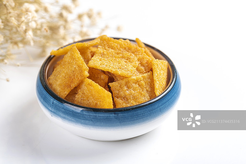 休闲零食小米锅巴与茶水摆放在桌面上特写图片素材