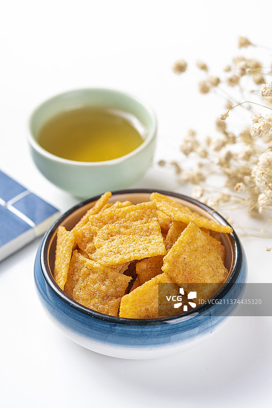 休闲零食小米锅巴与茶水摆放在桌面上特写图片素材