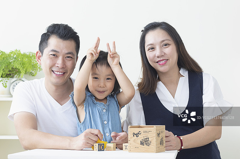 一起开心玩玩具的东方小家庭图片素材