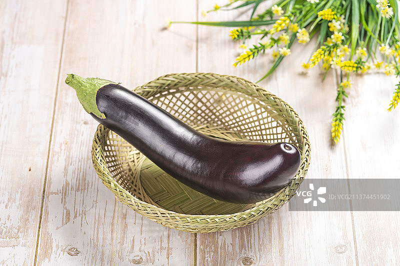 一簸箕紫红长茄子特写木桌面背景图片素材
